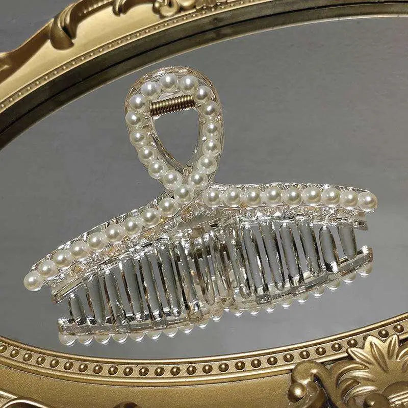 Clear acrylic pearl grab clip with white pearls and a rhinestone bow decoration for elegant hair styling