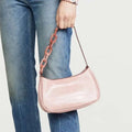 A blush pink trendy small crocodile bag with croc-embossed leather and a translucent rose gold acrylic chain strap