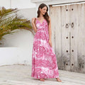 A flowing pink summer swing dress with tropical leaf print and thin spaghetti straps perfect for warm weather