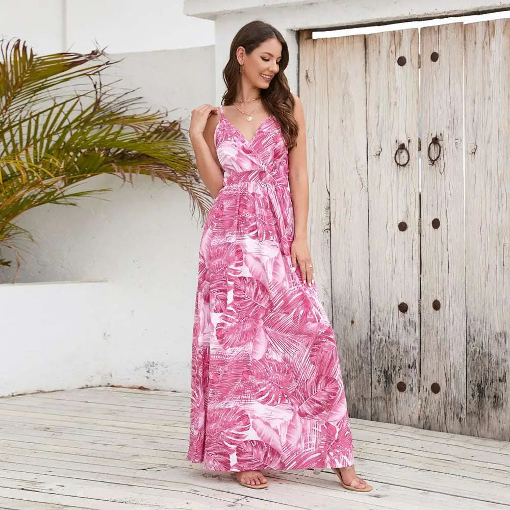 A flowing pink summer swing dress with tropical leaf print and thin spaghetti straps perfect for warm weather