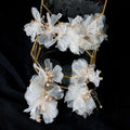 Delicate white organza tulle flower hair clips adorned with tiny pearls and gold-toned wire in tulle flower headband earring set