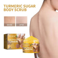 Yellow turmeric body scrub in clear jar with orange label and gold accents for exfoliating with jojoba and almond oil