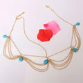 Gold-toned chain tasseled headband adorned with turquoise teardrop beads in an ethnic style design