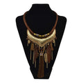 Gold-toned turquoise gold feather leaf tassel necklace with textured metalwork, brown leather cord, and dangling feathers
