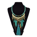 Turquoise gold feather leaf tassel necklace with hammered metal crescent, eye motif, and dangling feather charms