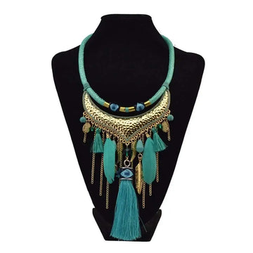 Turquoise gold feather leaf tassel necklace with hammered metal crescent, eye motif, and dangling feather charms