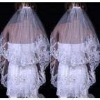 A delicate white two layer bridal sequined polyester veil with intricate lace and flowing sheer design