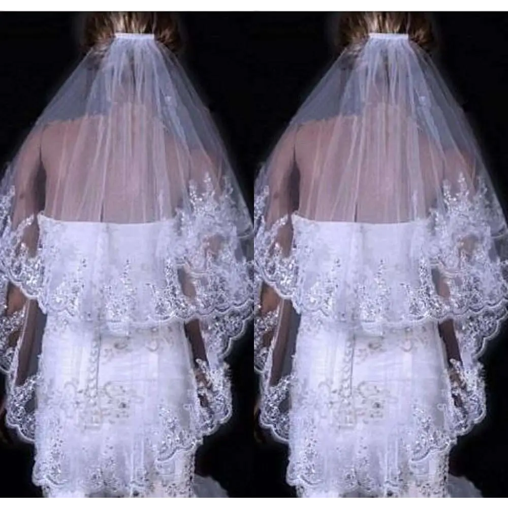A delicate white two layer bridal sequined polyester veil with intricate lace and flowing sheer design