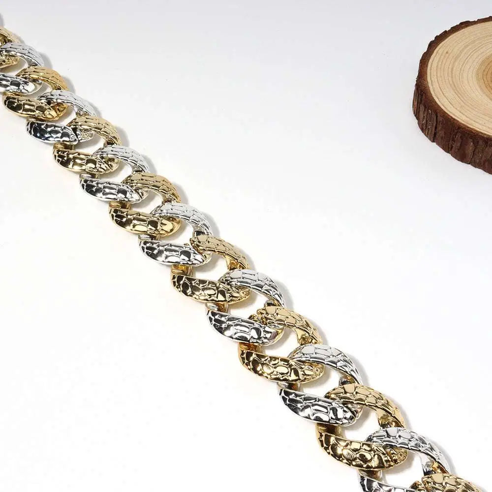 A two tone chain body jewelry belt featuring bold gold and silver hammered links for stylish summer body jewelry use