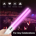 A pink glowing led light stick with white handle and silver metallic accents featuring wrist straps for concerts and parties