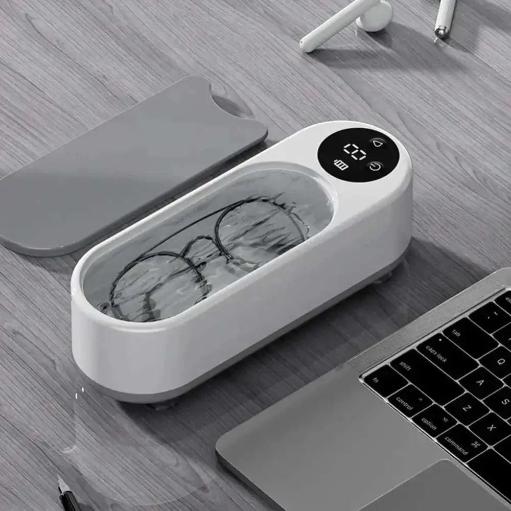 White and gray ultrasonic retainer cleaner machine with digital display showing temperature for dental care
