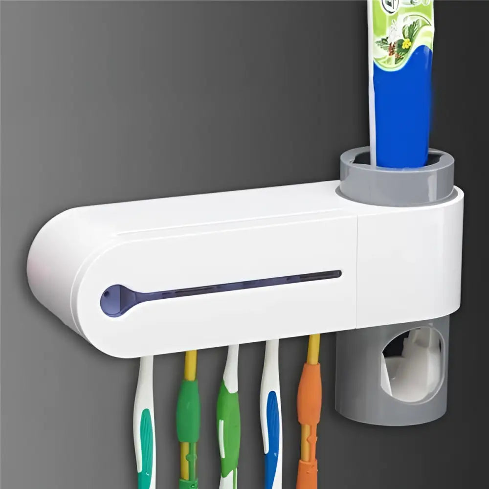 White plastic sterilizing toothbrush holder with gray accents and built-in toothpaste dispenser for multiple toothbrushes