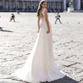 Back view of a flowing white chiffon wedding dress with lace sleeves and intricate lace detailing on the v-neck lace back