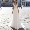 A flowing white chiffon wedding dress with v-neck lace bodice detailing and sheer lace sleeves for elegant occasions