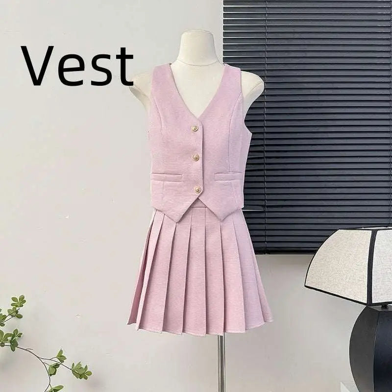 A soft pink v-neck vest with three gold-tone buttons and patch pockets paired with a high waist pleated skirt