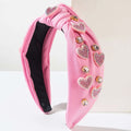 Pink valentines day headband with knotted love accessories featuring sparkling heart-shaped rhinestones and gold embellishments