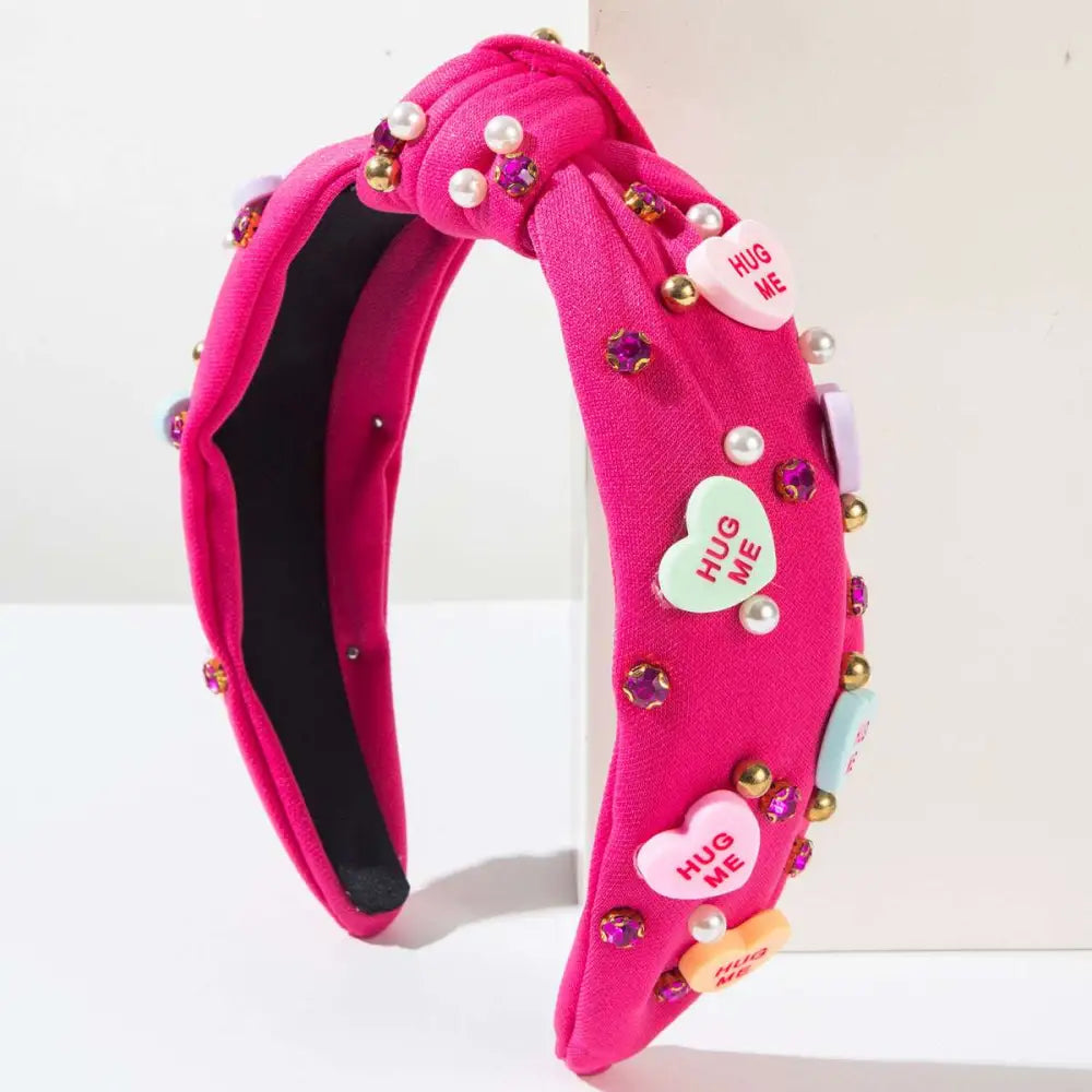 A vibrant pink valentines day headband knotted love accessories with pearl beads sparkling heart-shaped charms and candy hearts