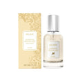 Clear glass bottle with silver cap and white label containing vanilla body hair perfume spray in sleek transparent design
