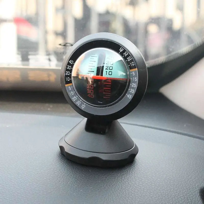 Black circular vehicle mounted sensing slope meter with clear lens, red needle, and numerical markings for precise angle measurement