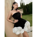 Black velvet strapless dress featuring voluminous white flower pettiskirt french ruffles at the hem