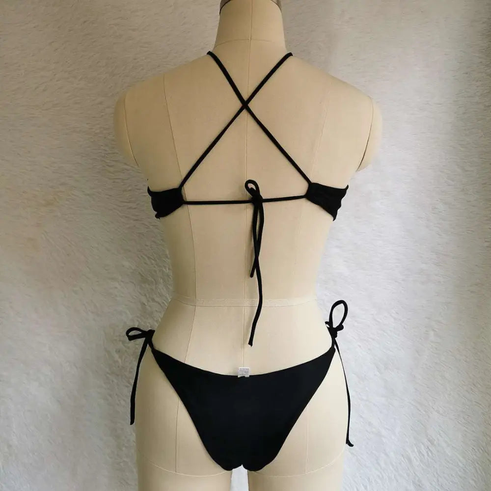 Back view of a black string bikini with crisscross back and side ties in a vibrant blue cutout color swimsuit design