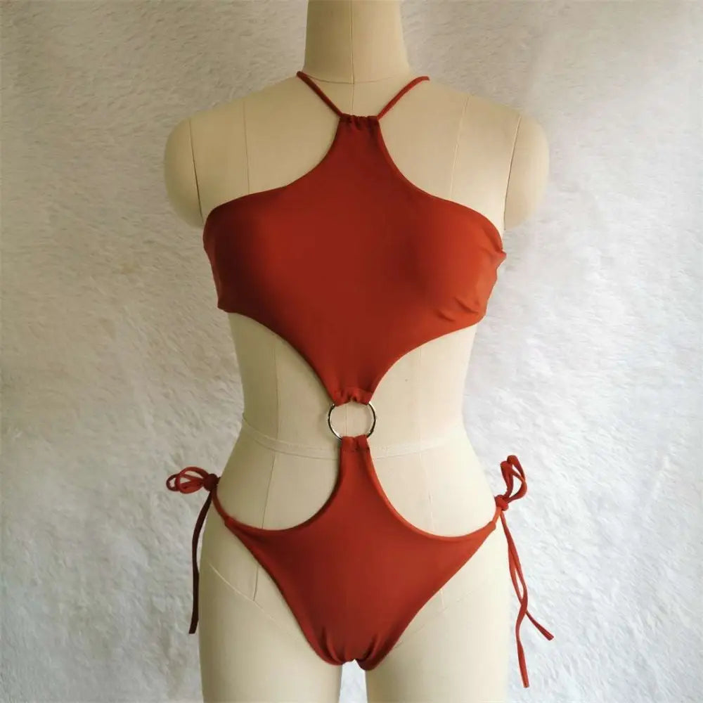 A rust-colored one-piece swimsuit with halter neckline and cutout details, contrasting vibrant blue cutout bikini style