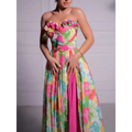 A vibrant strapless floral print maxi dress with ruffled bodice detailing and a bold pink side slit