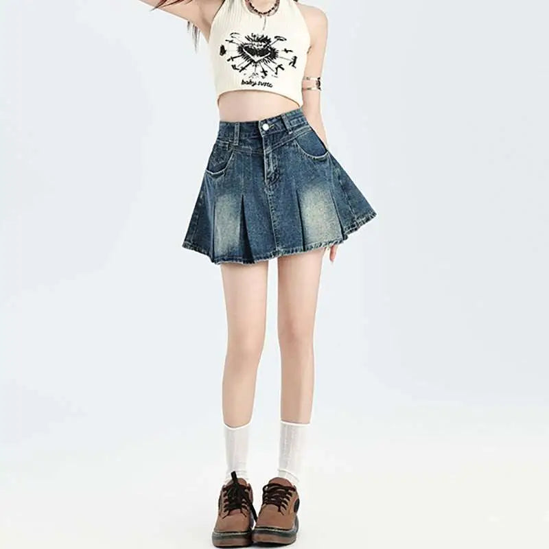 High-waisted vintage denim skirt with pleats and faded blue wash paired with a cream halter set