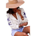 White blouse featuring vintage floral embroidered blue design with ruffled embroidered puffed sleeve accents