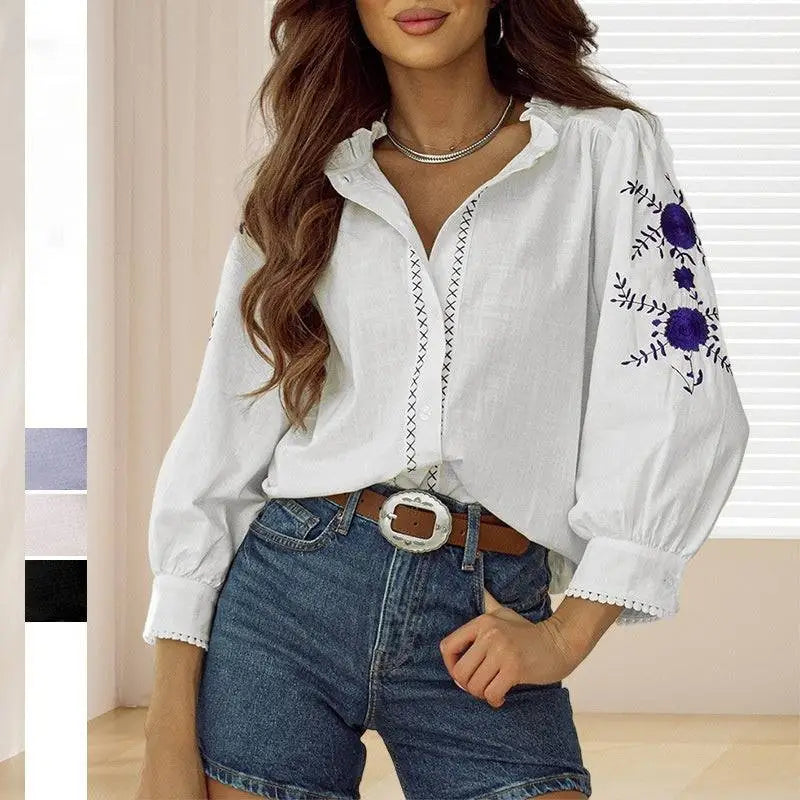 White blouse with vintage floral embroidered purple flowers on the sleeve and lace trim at the cuffs