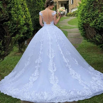 Back view of a vintage lace white wedding dress with an open back and floral train featuring intricate embroidery on main fabric
