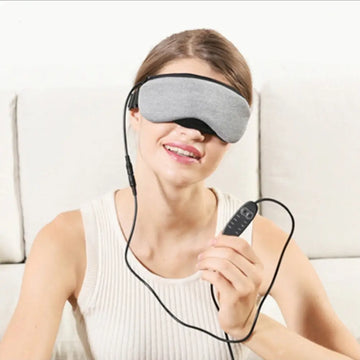 Visionary smart eye massager mask in gray fabric with black adjustable straps and matching remote control for relaxation