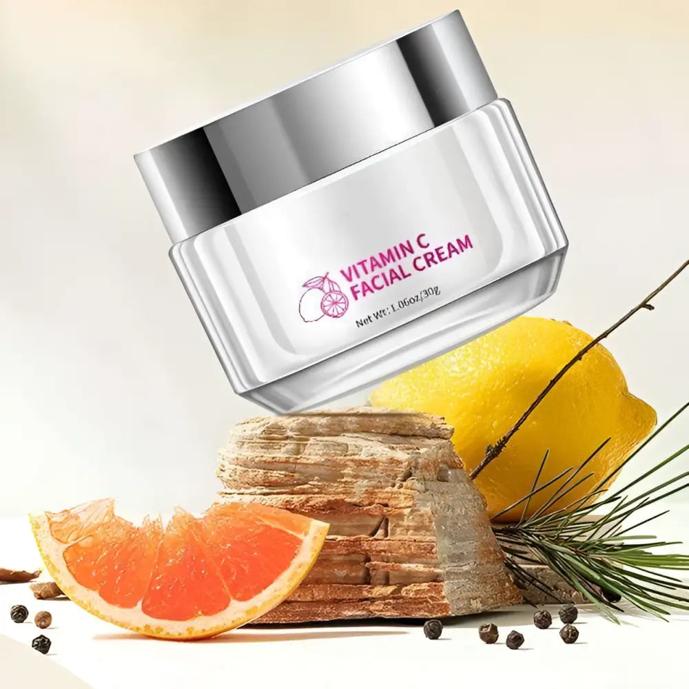 A sleek silver jar of royale essence lux vitamin c brightening face cream with a transparent body and orange slice label
