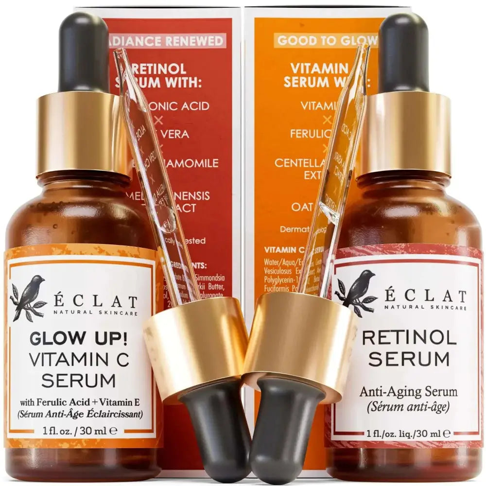 Two amber glass dropper bottles of éclat vitamin c serum and retinol serum set with gold caps and black rubber bulbs