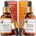 Two amber glass dropper bottles of éclat vitamin c serum and retinol serum set with gold caps and black rubber bulbs