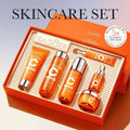 Orange rectangular box containing a vitamin c whitening skin care gift set with five distinct product bottles and metallic accents