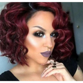 A woman wearing a voluminous burgundy curly european beauty wig with bold makeup made of high temperature wire fibers