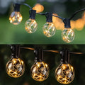Warm waterproof string lights featuring clear glass globes with black sockets and warm golden filaments