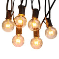 Warm waterproof string lights featuring clear glass globes with brass bases and black cords for outdoor use
