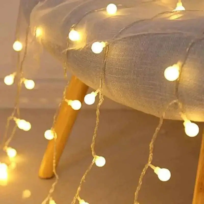 Warm yellow sunshine pearl lights with delicate woven wire led pearls draped over a cushioned chair edge