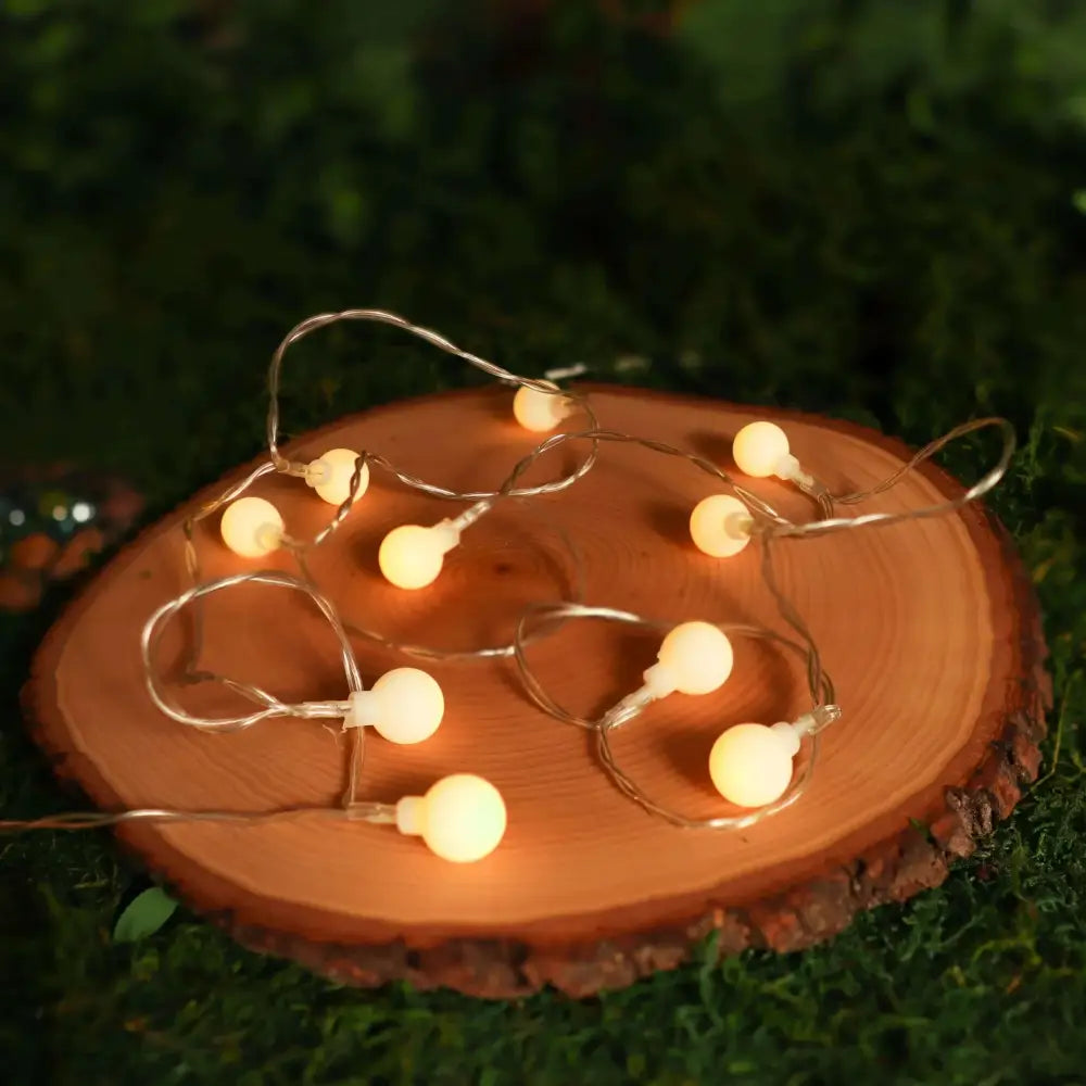 Warm yellow sunshine pearl lights featuring warm white led pearls with frosted glass bulbs on thin metallic wire