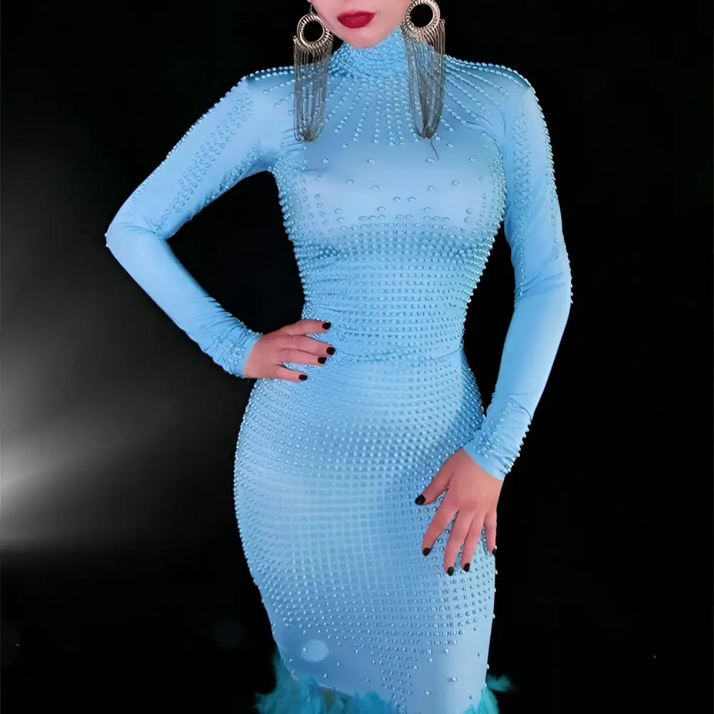A light blue mermaid gown with a form-fitting silhouette, sparkling bead pattern, and feather trailing hip trim