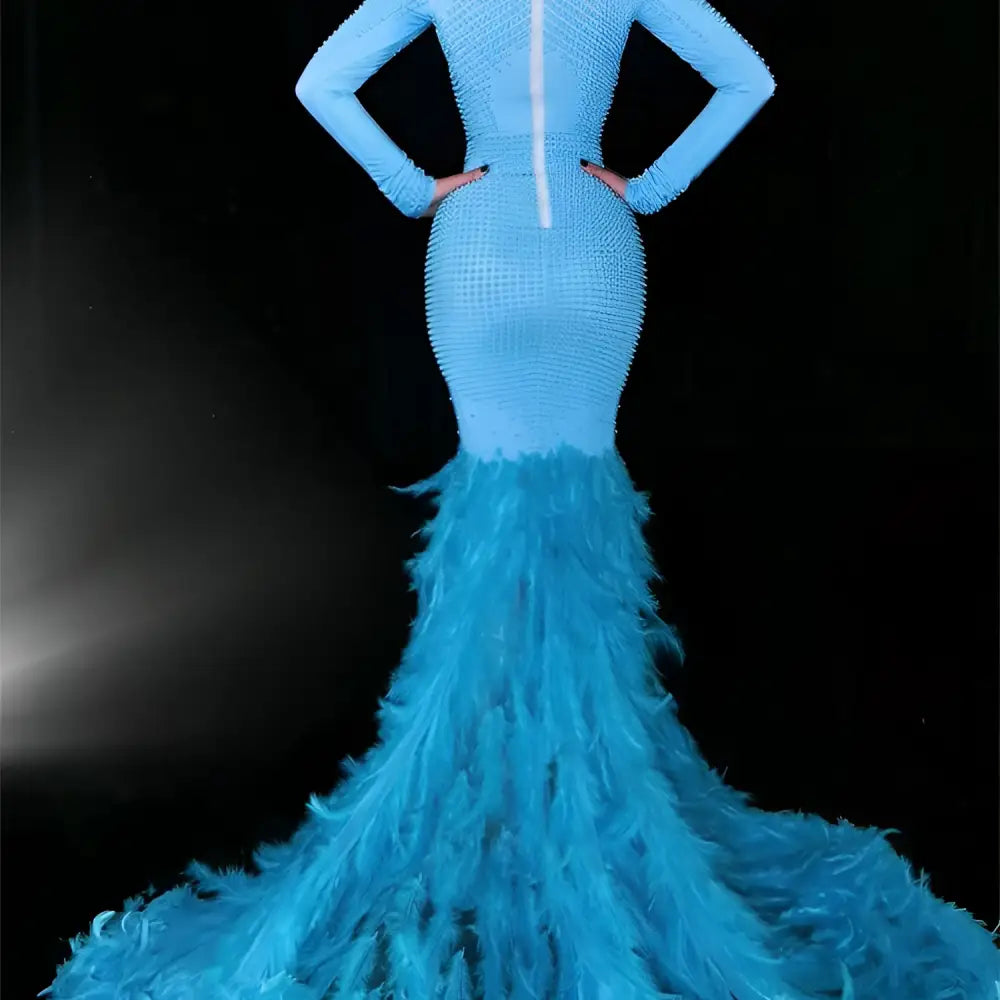 A striking light blue mermaid gown with a beaded bodice and a feather trailing hip train