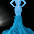 A striking light blue mermaid gown with a beaded bodice and a feather trailing hip train