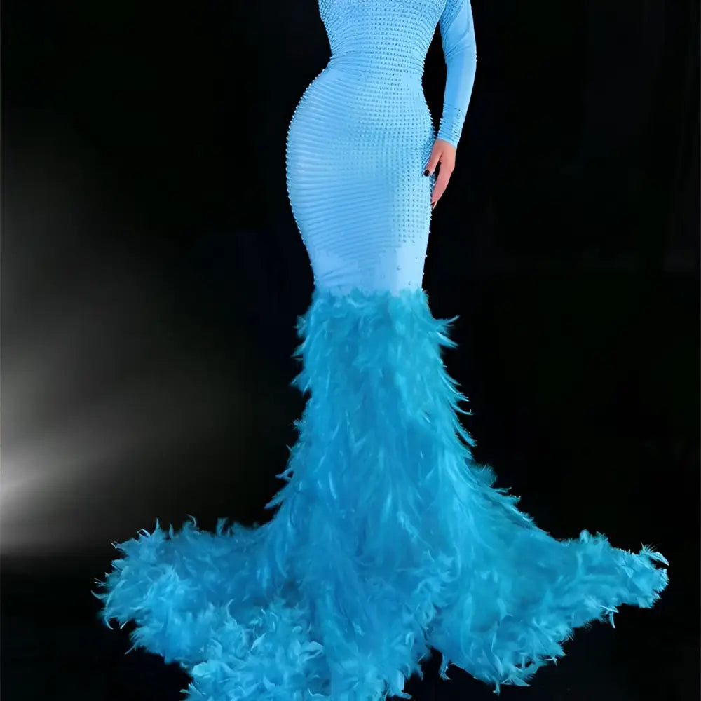 A striking light blue mermaid gown with a textured beaded bodice, long sleeves, and an extravagant feather trailing train