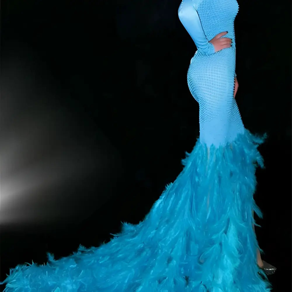 A striking light blue mermaid gown with a beaded bodice and a feather trailing hip train