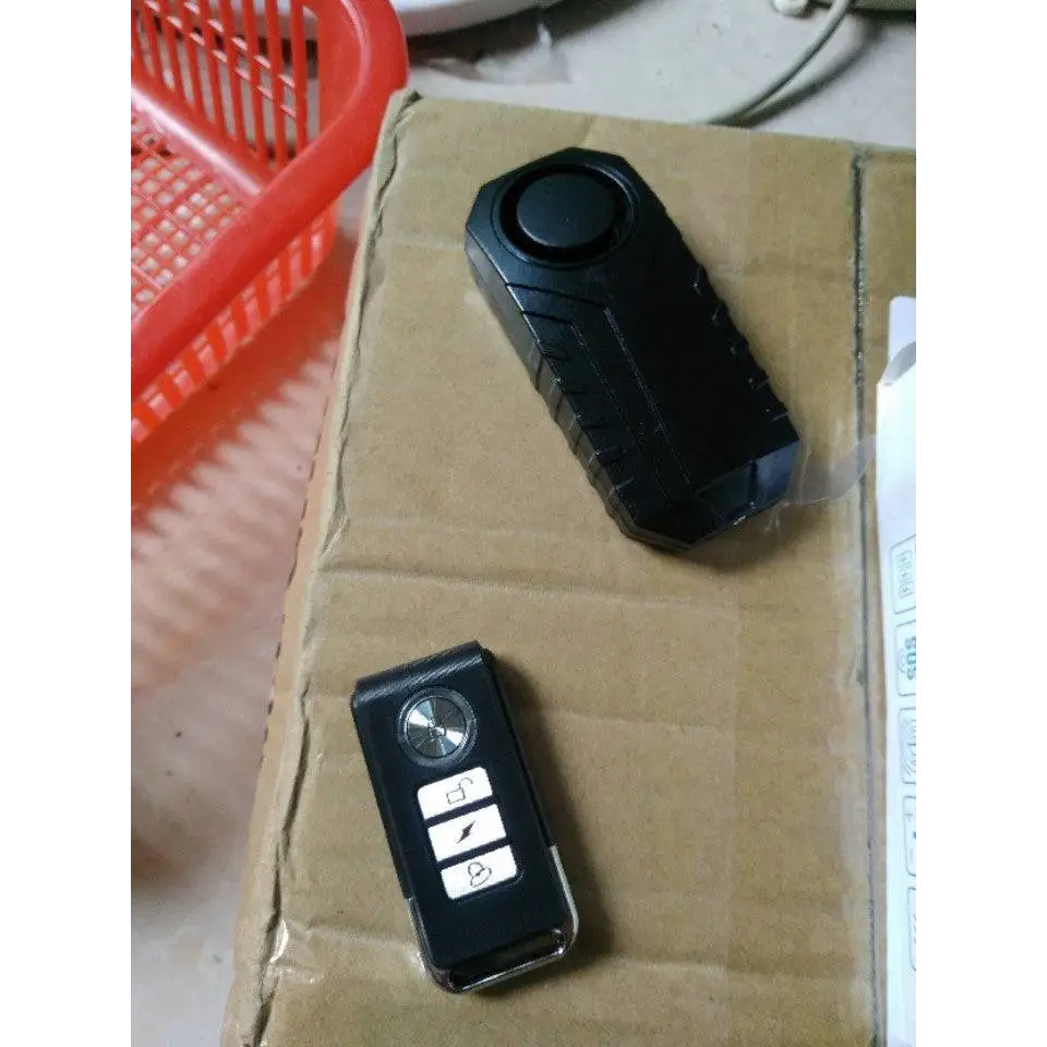 Black plastic waterproof bike alarm remote control anti theft system with textured grip and three function buttons