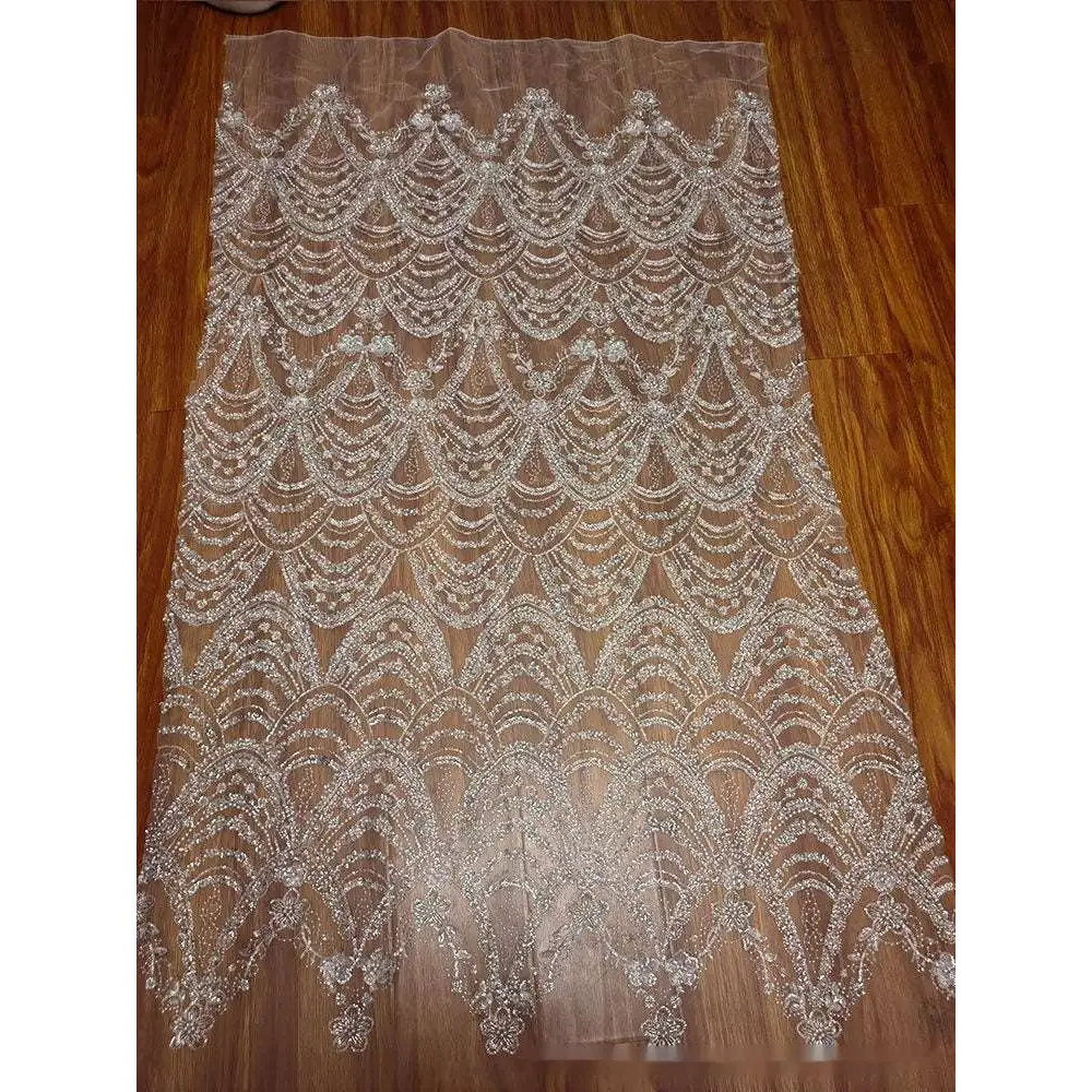Sheer silver lace fabric with intricate silver wave style sequin bead lace in a scalloped pattern for wedding dresses