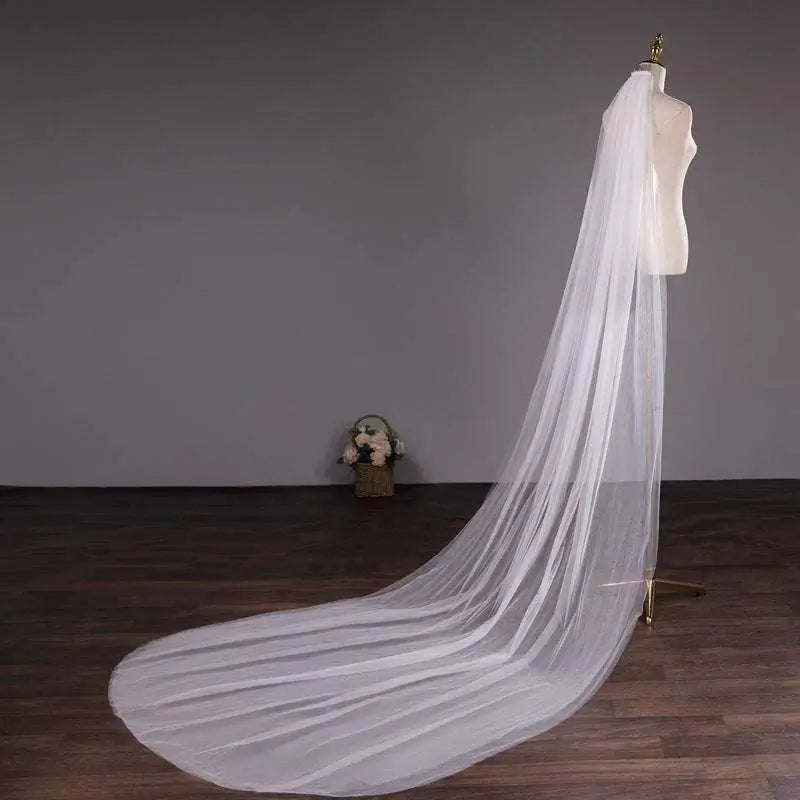 A white tulle wedding bride double-layer trimming veil with comb elegantly draped over a mannequin
