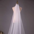 A delicate white tulle wedding bride double-layer trimming veil with comb elegantly draped on a mannequin